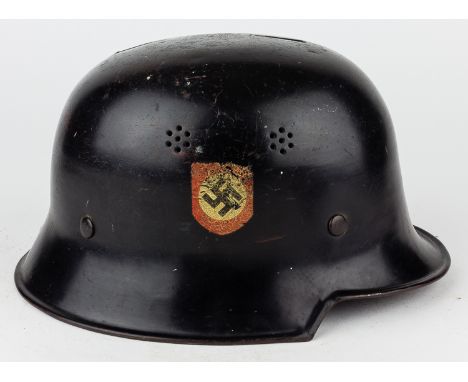 GERMAN FIRE PROTECTION POLICE HELMETSteel alloy M1934 combat helmet, painted black overall, with a shield-shaped swastika dec