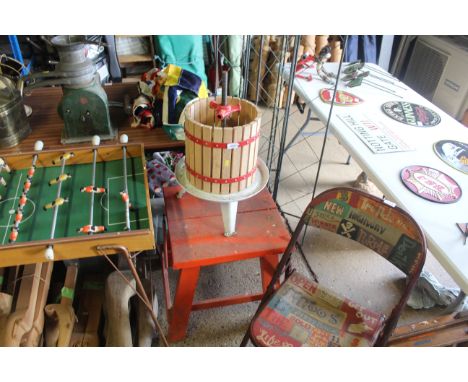 A vintage wooden and metal bound fruit press mounted to wooden table 