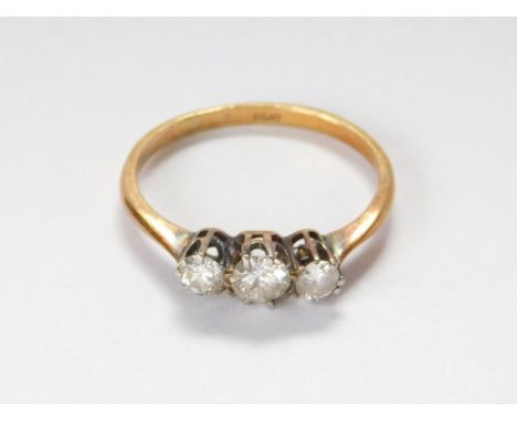 DIAMOND RING. A yellow metal (probably 18ct.) & platinum three stone diamond ring. Size K/L. Approx. 1.6g.  Please note that 
