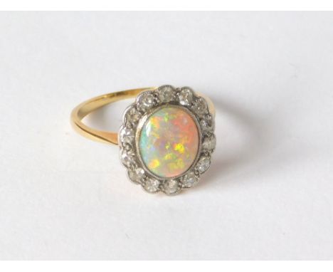 OPAL RING. An opal & diamond cluster ring set in yellow metal (probably 18ct. gold, marks worn). Size I/J. Approx. 2,5g.  Ple