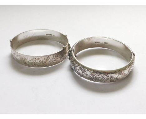 SILVER BANGLES. A mid 1960's hinged silver bangle & one other hinged silver bangle, Birmingham 1977.  Please note that all it