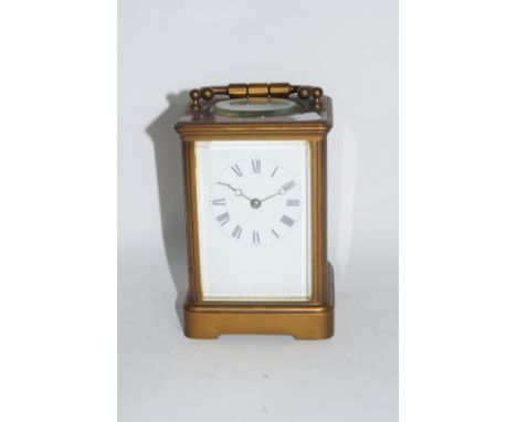 Brass carriage clock with white enamel dial and Roman numerals in black, 12cm high