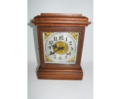 Early 20th century mantel clock, pressed metal dial to a brass movement striking on a coiled gong set in an oak case with ste