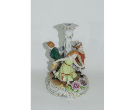 Continental porcelain candlestick in Meissen style decorated with children dancing around a central column, 26cm high