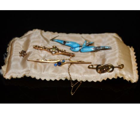 A 9ct gold and blue stone stick brooch; a knot brooch; a tie pin ; an enamel Bluebird brooch (5)