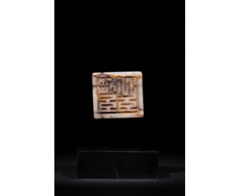 A Chinese Jade Seal with Archaistic Script.A seal finely carved from a creamy jade with prominent russet and black veining th