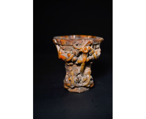 A Chinese Carved Libation Cup with Dragons and Taotie Mask, with Character Marks to the Base.A dark caramel-toned libation cu