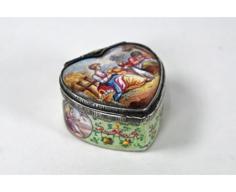 A 19th Century Continental enamel heart-shaped pill box the silver hinge stamped as .800 grade Austro-Hungary, the lid painte