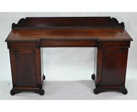 A Regency mahogany inverted breakfront pedestal sideboard, with trio of frieze drawers over cupboards, raised on moulded brac