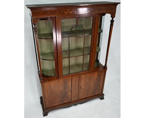 An Edwardian Sheraton Revival style inlaid satinwood display cabinet, with bowed side panels flanking an astragal glazed door