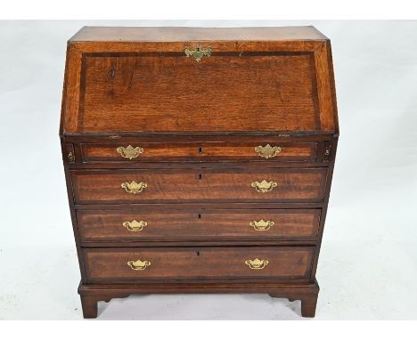 A George III crossbanded oak bureau with fitted interior over four long graduated drawers, on shaped bracket feet, 97 cm wide