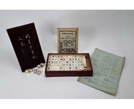 A Chinese Mah-Jong set with one hundred and fifty one resin and bamboo tiles in a stained hardwood case c/w 'Directions of Pl