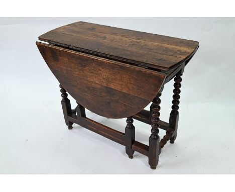 A late 18th/19th century oak gateleg table, the oval drop leaf top raised on a bobbin turned frame, 116 cm long x 92 cm wide 