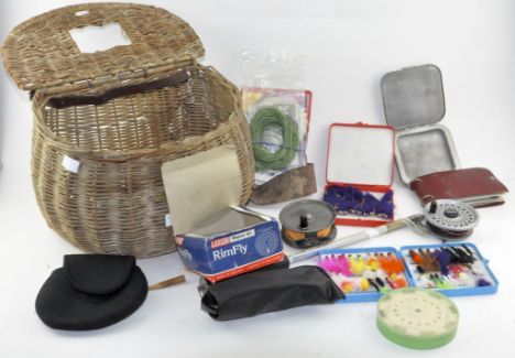 Assorted fishing items, including fishing reels, fly and cast boxes and other fly fishing tackle in basket