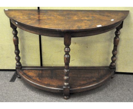 An oak early 20th century demi-lune side table, with lower shelf, on turned baluster legs, 77 cm high x 120 cm wide x 46 cm d