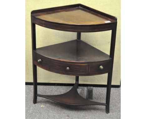 An early 19th century mahogany corner wash stand, with railed triangular top over a unit with central drawer and two sham dra