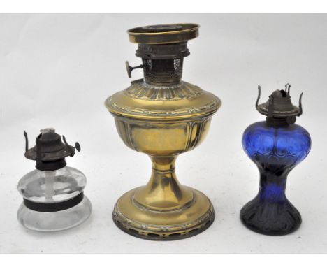 Three oil lamps, including a brass Aladdin lamp, model no 9 and two glass examples, the first 33 cm high 