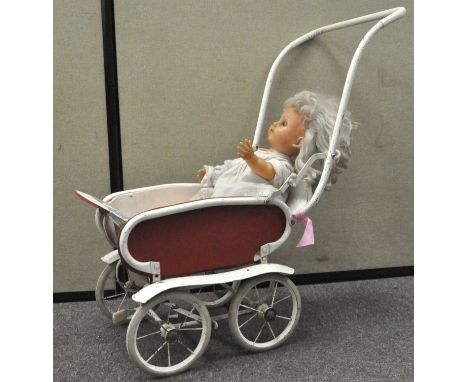 A vintage plastic doll in a pram, the pram 78cm high (inc handle)