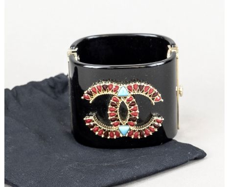 Chanel, breite Vintage Armspange, schwarzer Kunststoff mit Klappscharnier und partiellem Schmucksteinbesatz in Form des CC-Lo