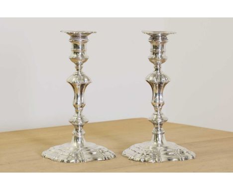 Two George II cast silver candlesticks,both probably by James Gould, each have a different maker's mark for the silversmith, 