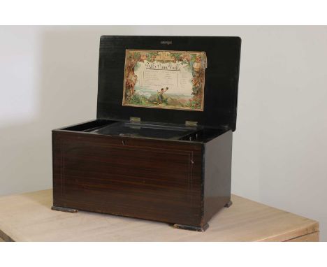 An eight-air musical box with bells and drums in sight,the rosewood lid with strung and inlaid decoration over a grained base