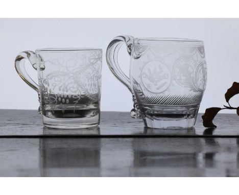 A George III glass mug, c.1800, of swollen form with a reeded and looped handle, engraved with a cypher enclosed by two engra