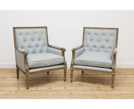 A pair of modern Louis XVI-style armchairs,by Nordic Style, each with a limed oak frame with a woven light blue buttoned fabr