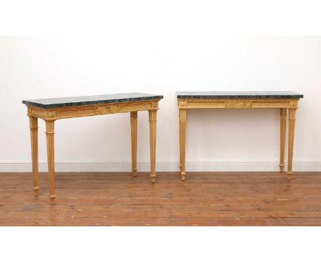 A pair of giltwood console tables in the manner of Robert Adam, 19th century, each with a fluted frieze, centred with a folia