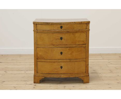 A small Empire satin birch commode,c.1810, Danish, of bow-fronted outline, set with four graduated drawers, each with a shiel