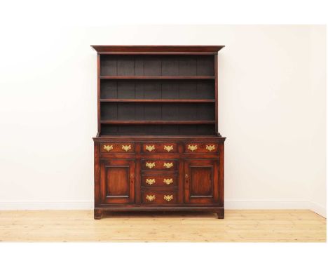 A pine and fruitwood dresser,late 19th century, the plate rack back over three drawers, with further drawers and cupboards be