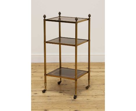 A three-tier étagère occasional table,20th century, the mahogany shelves held on turned brass supports terminating in brass c