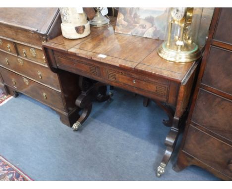 A REGENCY MAHOGANY GAMES TABLE, the top with reversible slide, the interior with leather-lined backgammon board;  fitted two 