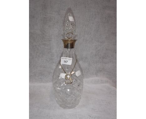 A SILVER MOUNTED GLASS DECANTER with a Victorian Irish silver label, in the form of an 'S' with engraved floral decoration, t