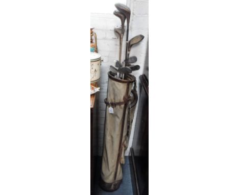 A COLLECTION OF VINTAGE GOLF CLUBS contained in a leather trimmed canvas bag