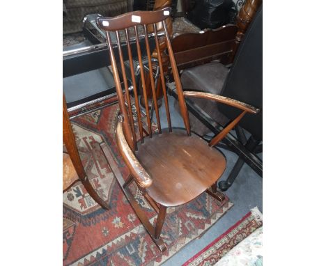 ERCOL: A STAINED ELM STICK-BACK ROCKING CHAIR