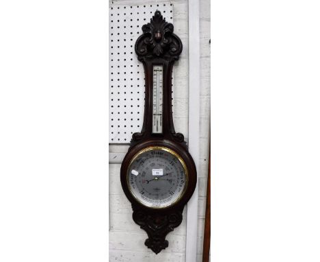 A BANJO BAROMETER with a carved oak case  