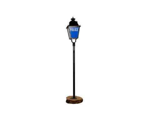 A retro black metal Police street lantern, on black metal screw pattern stem and wooden block base, 255cms high.