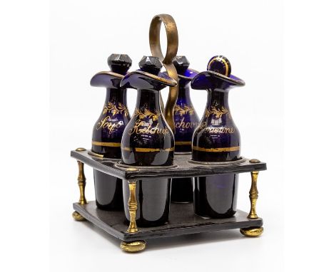 A Georgian Bristol blue glass four-bottle cruet, of mallet form with everted rims and faceted stoppers, gilt labels for Cayen