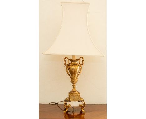 A reproduction French gilt metal and marble table lamp, of vase form with swan handles, set on a black-veined white marble ba