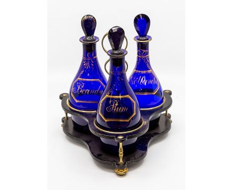 A set of three Georgian Bristol blue glass decanters and stoppers, of mallet shape and with faceted teardrop stoppers, each w