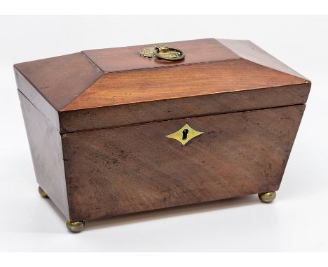 A George III mahogany tea caddy, of sarcophagus form with brass ring handle, the hinged top enclosing a fitted interior with 