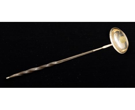 An 18th Century silver punch ladle, the oval bowl inset with a George III coin dated 1787, on a twisted whalebone handle with