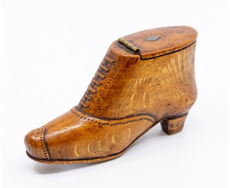 An early 19th Century treen snuff box, modelled as a boot with carved laces and stitching detail, the hinged top with metal l