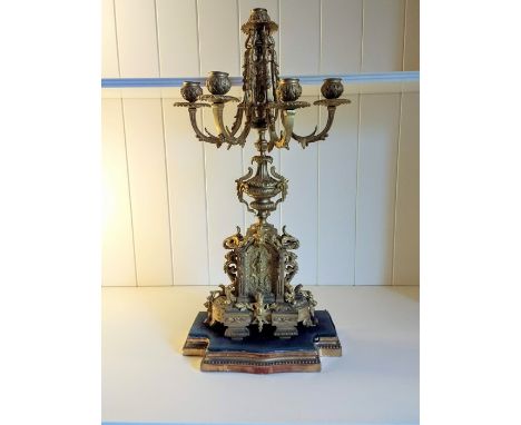 A French ormolu four-branch candelabra, late 19th Century, the architectural form base moulded with masks, leaves and lion he