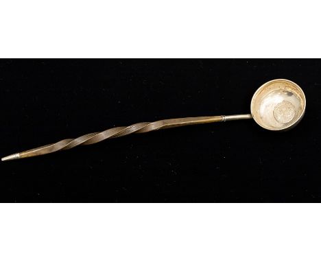 An 18th Century silver punch ladle, the circular bowl inset with a Queen Anne shilling dated 1711, the handle of twisted whal