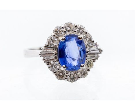 A sapphire and diamond 18ct white gold cluster ring, comprising a central oval sapphire approx. 2carats, within a border of r