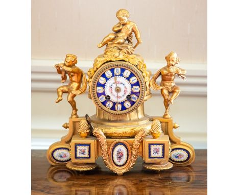 A French ormolu and enamel mantel clock, late 19th Century, the movement surmounted by a putto and flanked by two further put