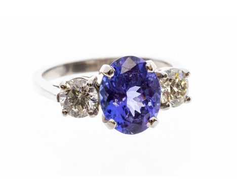 A tanzanite and diamond platinum ring, the claw set oval tanzanite measuring approx. 10mm x 7.8mm x 5.5mm, weighing approx. 2