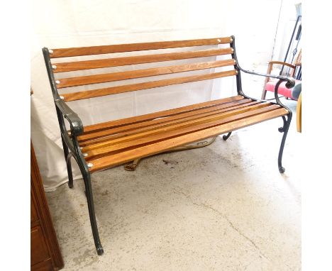 A wrought-iron and hardwood slatted garden bench (plaque to the rear for C F Fredrikson), length 127cm 