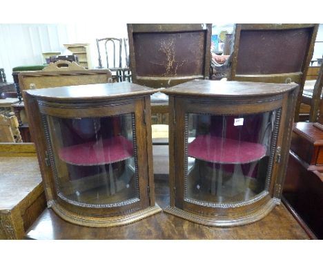 A pair of oak bow front hanging corner cabinets (cracked glass to one)